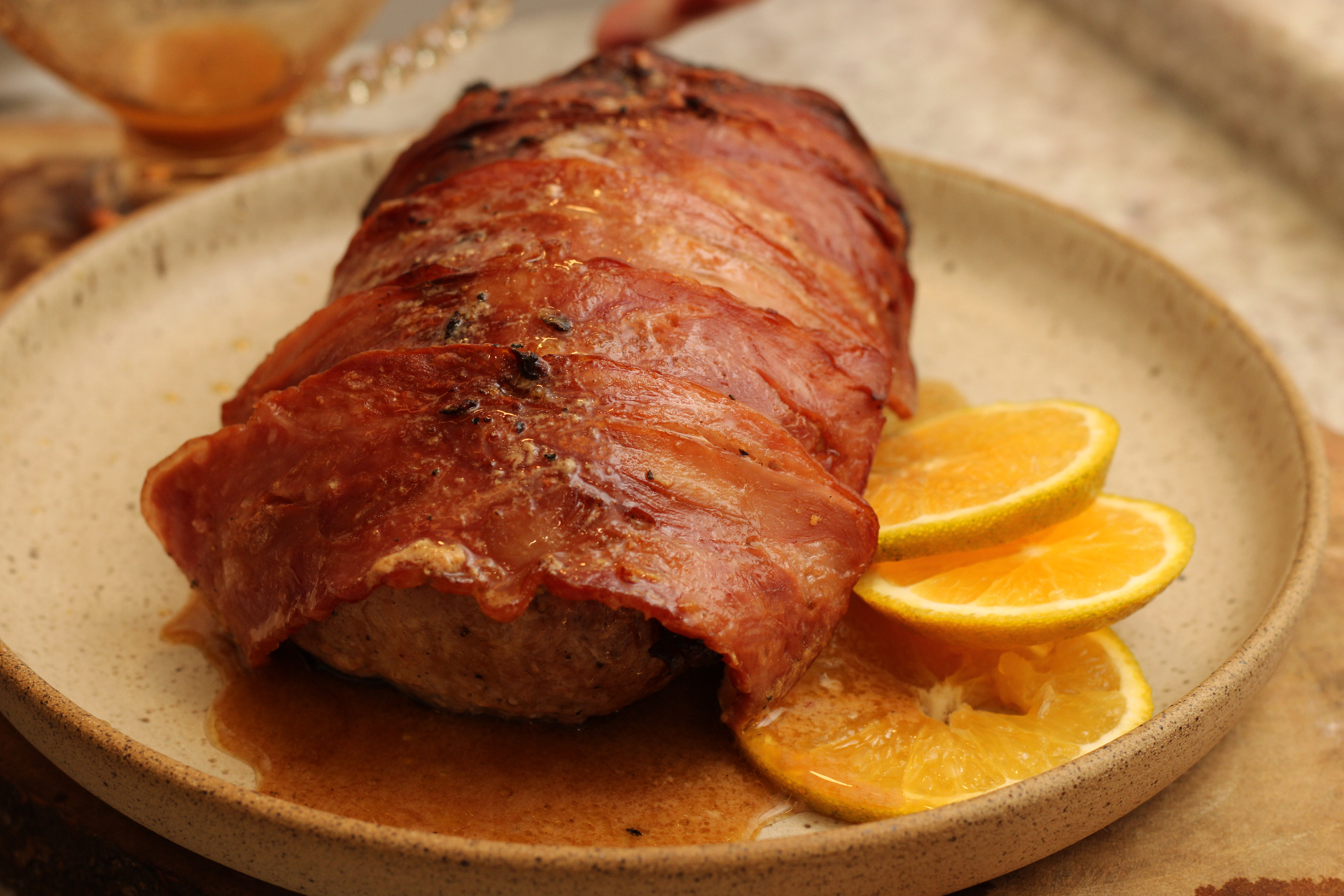 Lombo enrolado em bacon ao molho de laranja